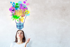 A colorful "lightbulb" depiction of a woman brainstorming ideas for her health coaching business.